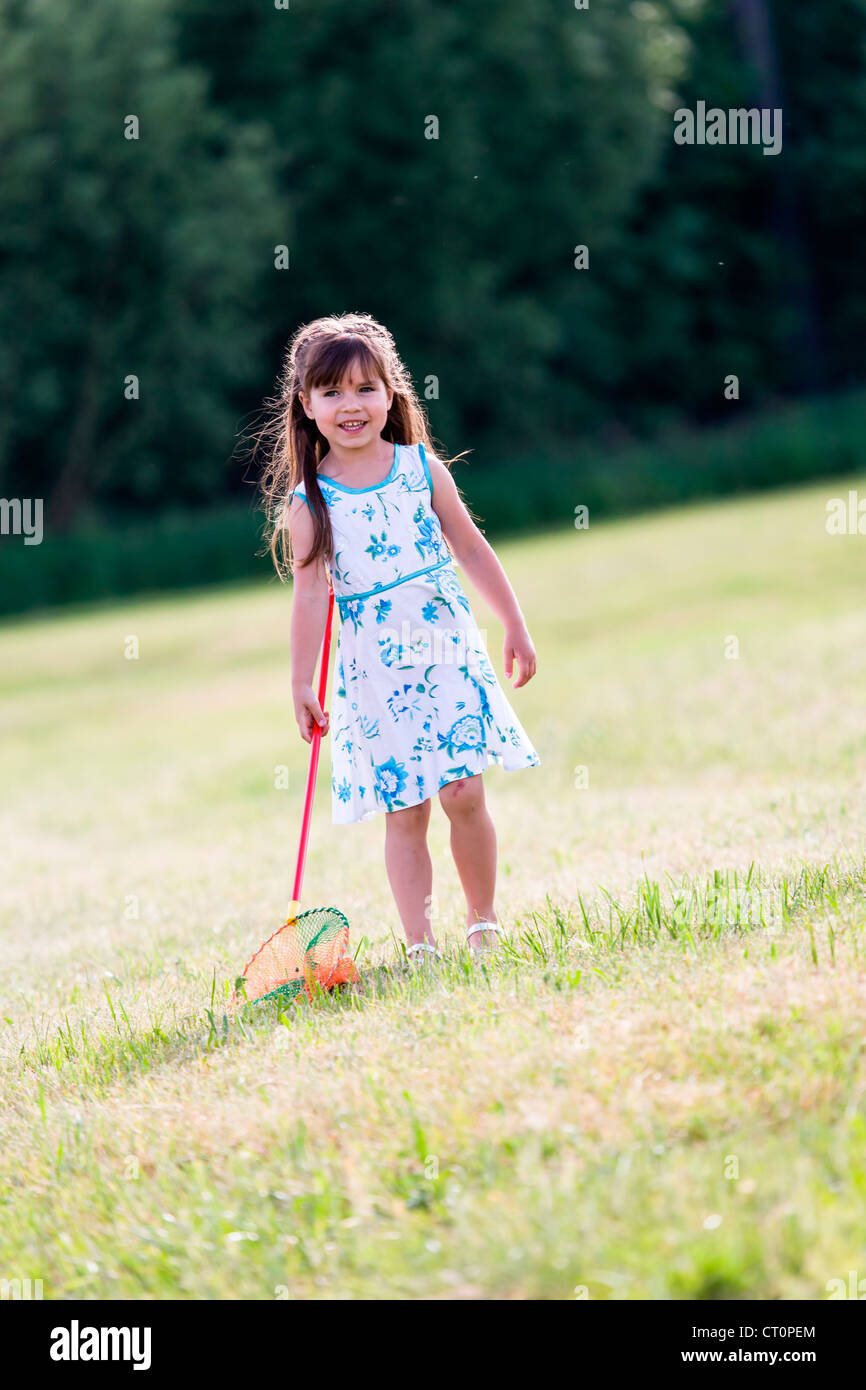girl playing with butterfly net in the garden Stock Photo