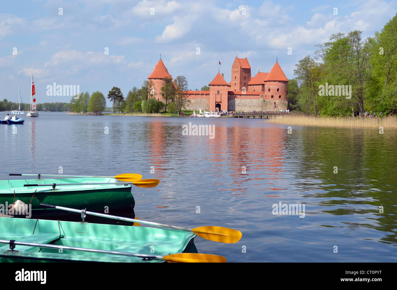 Boats on Galve lake shore and Trakai Castle in Lithuania. Floating boats and water bikes. Active outdoor recreation. Stock Photo