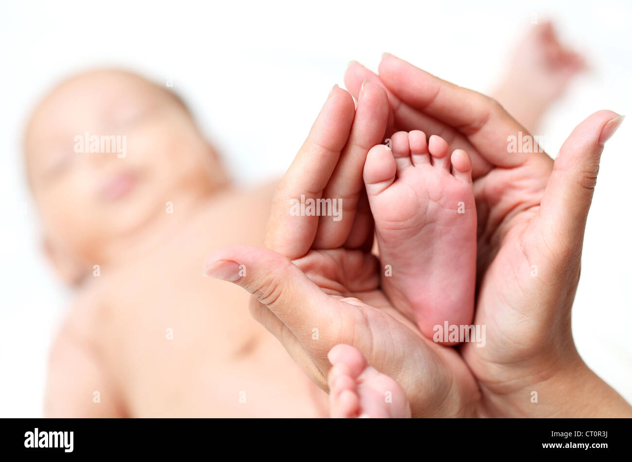 Clouse-up of newborn baby's foot in mammy's hands Stock Photo