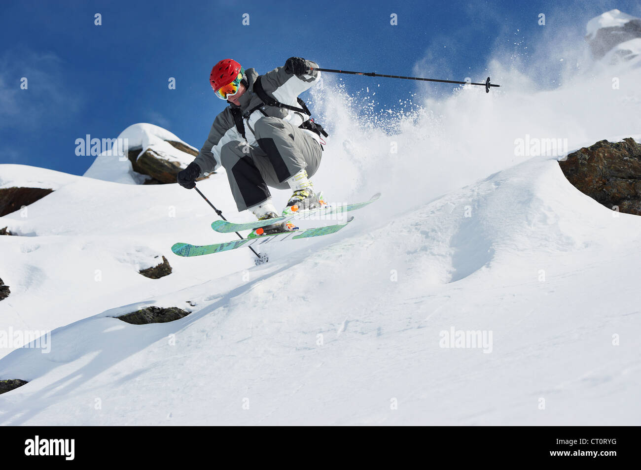 Skier jumping off snowy slope Stock Photo