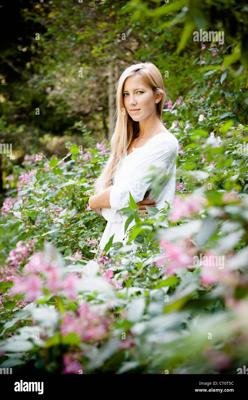 Woman standing in flower bushes Stock Photo - Alamy