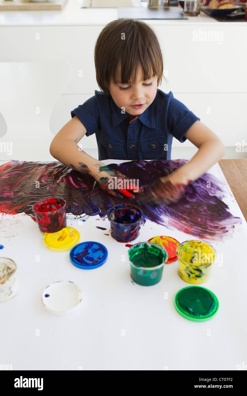Boy finger painting on paper Stock Photo