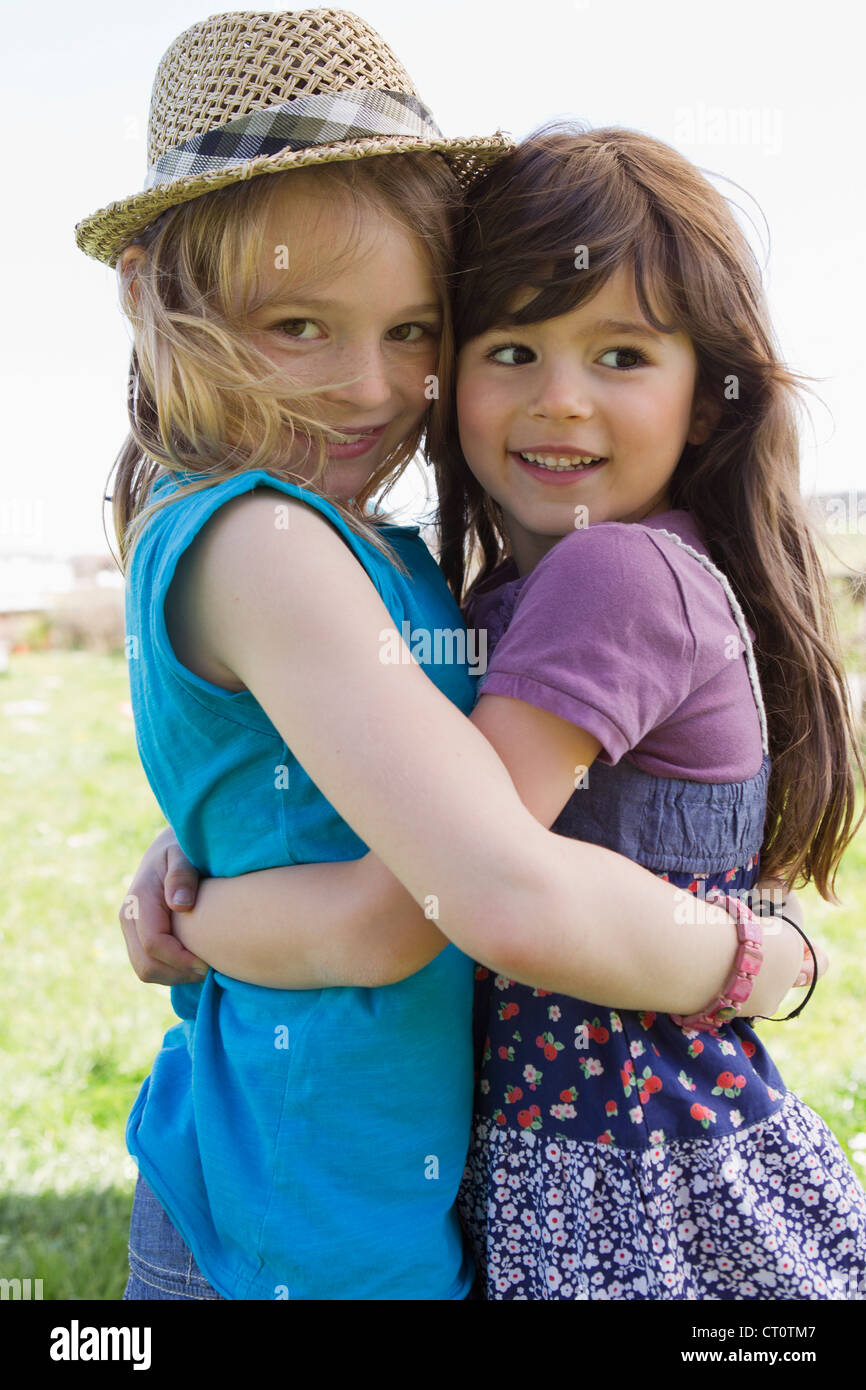 Smiling girls hugging outdoors Stock Photo - Alamy