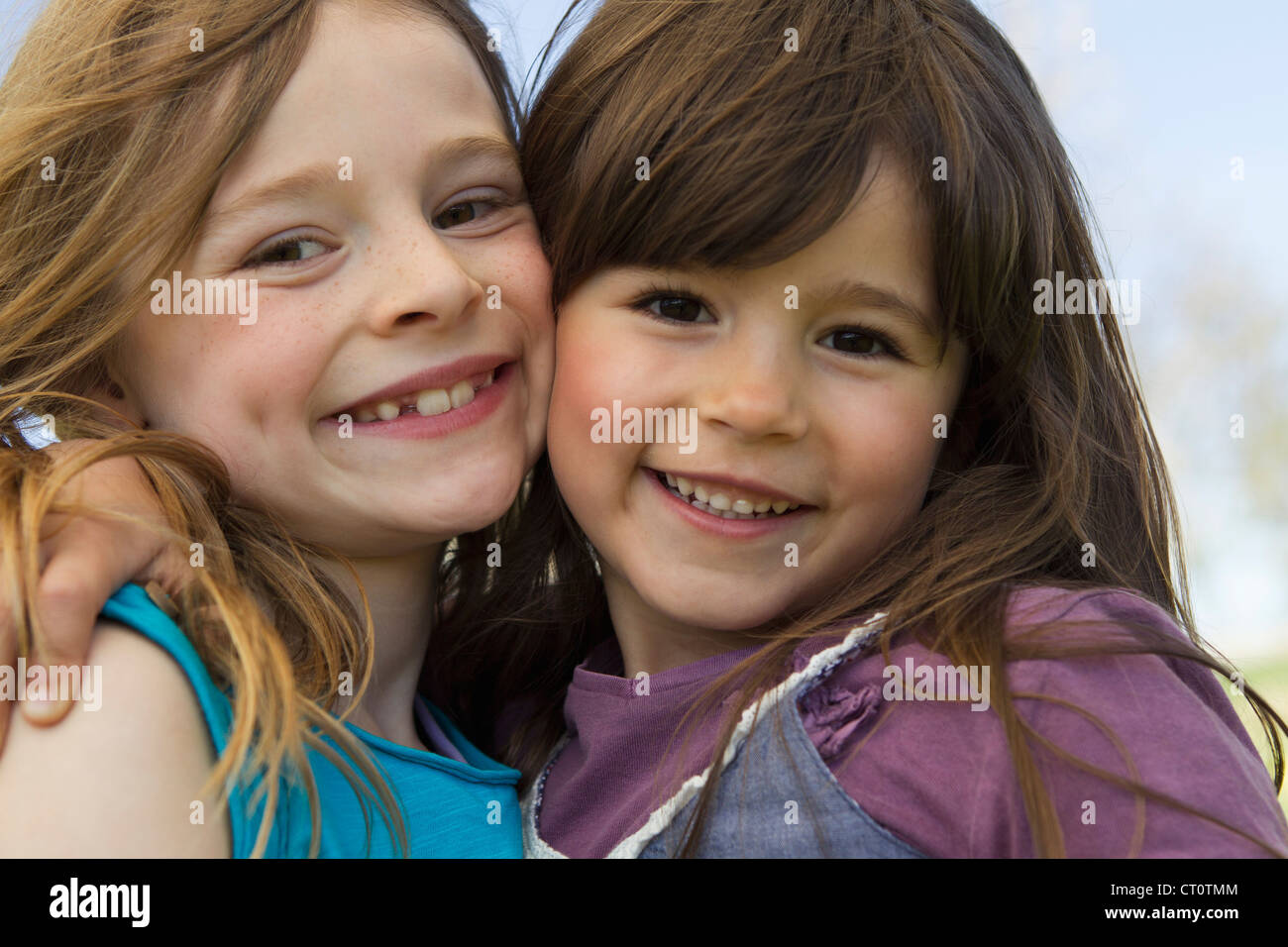 Smiling girls hugging outdoors Stock Photo - Alamy