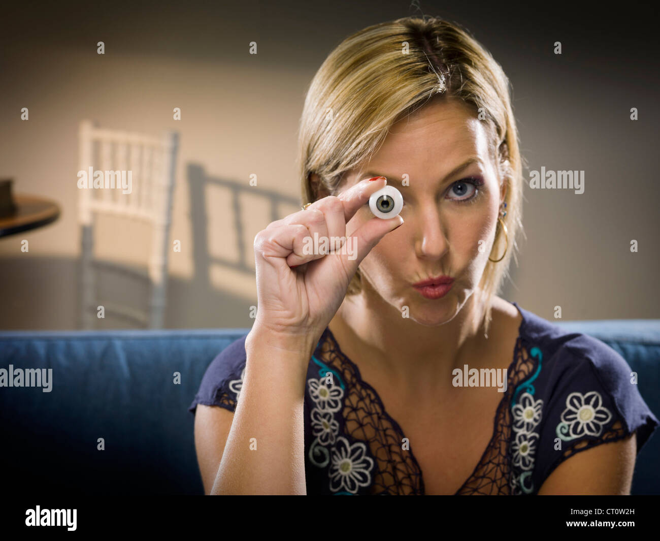 Woman holding glass eye in living room Stock Photo Alamy