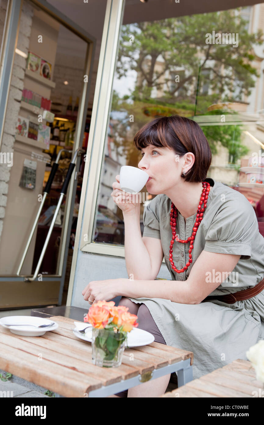 Woman having coffee at sidewalk cafe Stock Photo