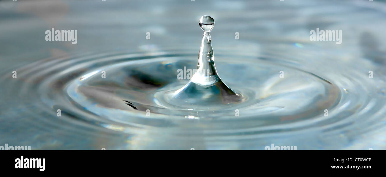 single water drop splashing in clear water Stock Photo