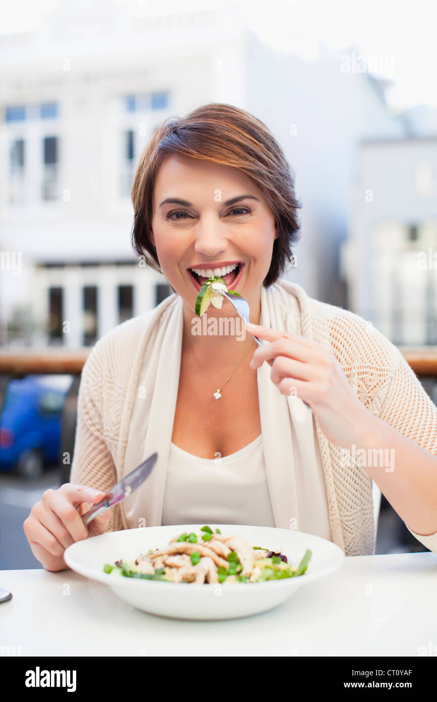 Woman eating at sidewalk cafe Stock Photo