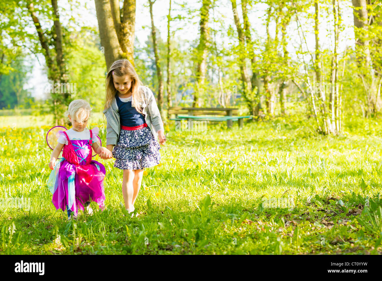 Girls walking together in field Stock Photo - Alamy