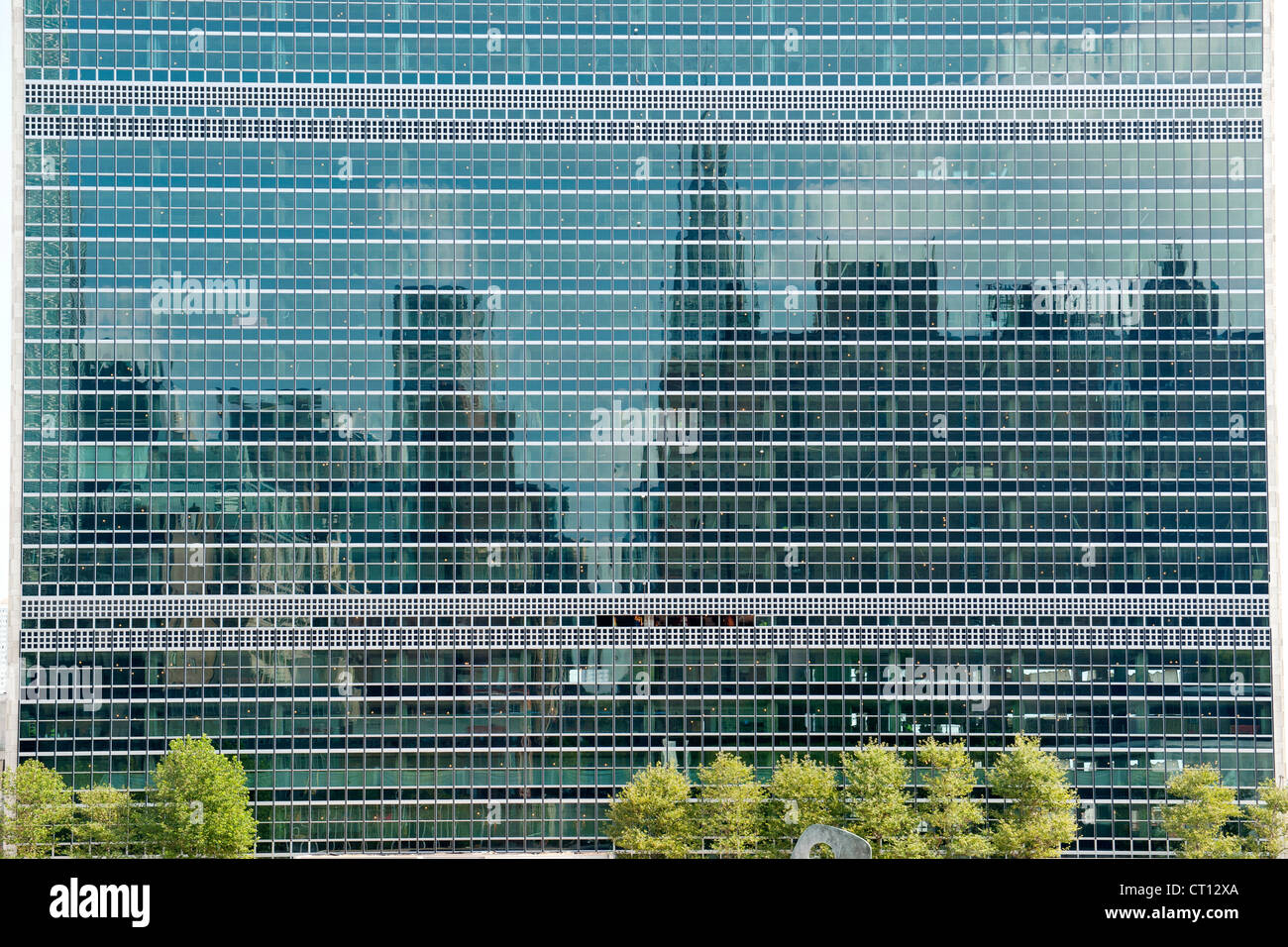 The Manhattan skyline reflected in the windows of the United Nations building in New York City, USA. Stock Photo