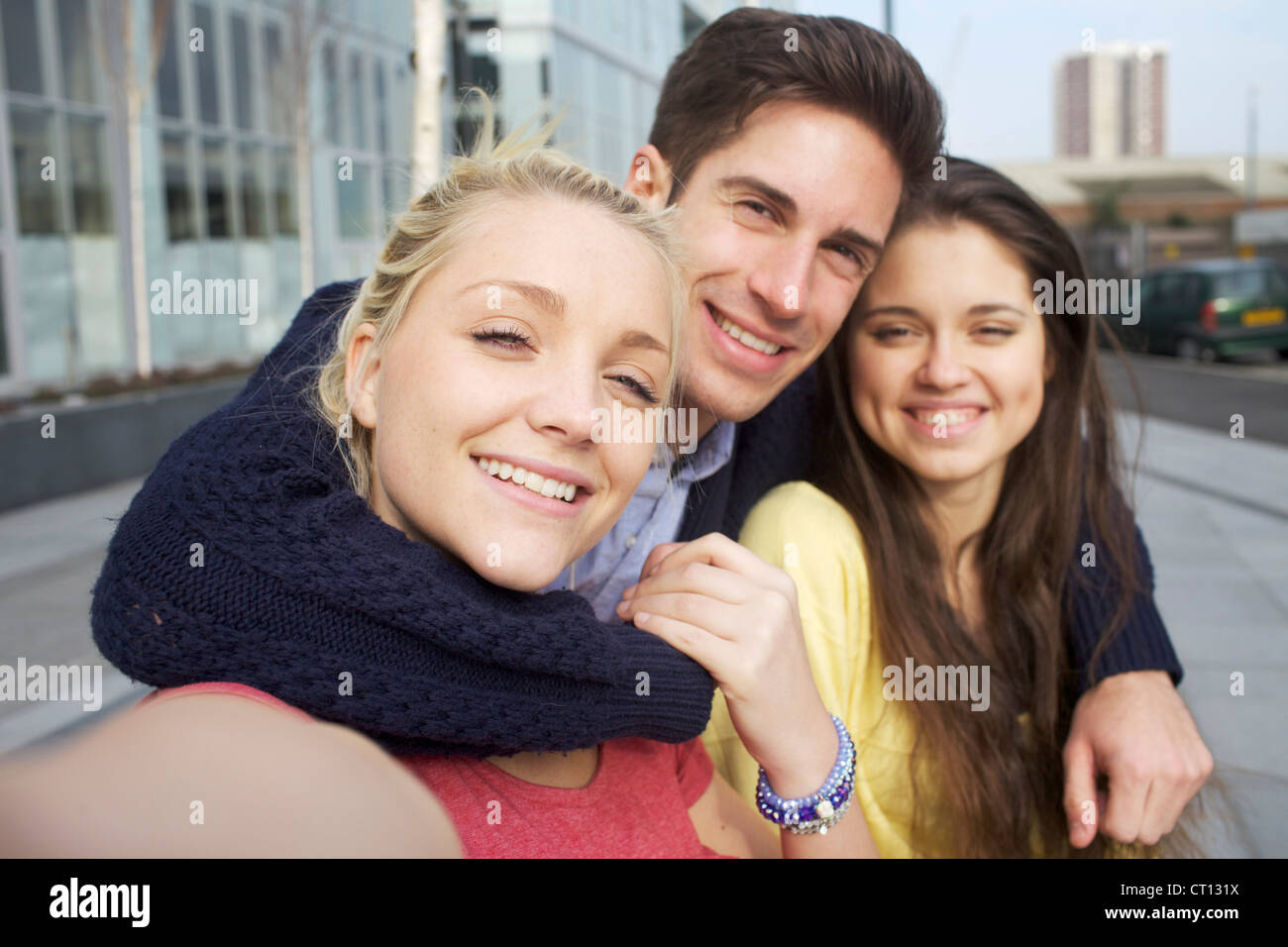 Friends smiling together on city street Stock Photo - Alamy
