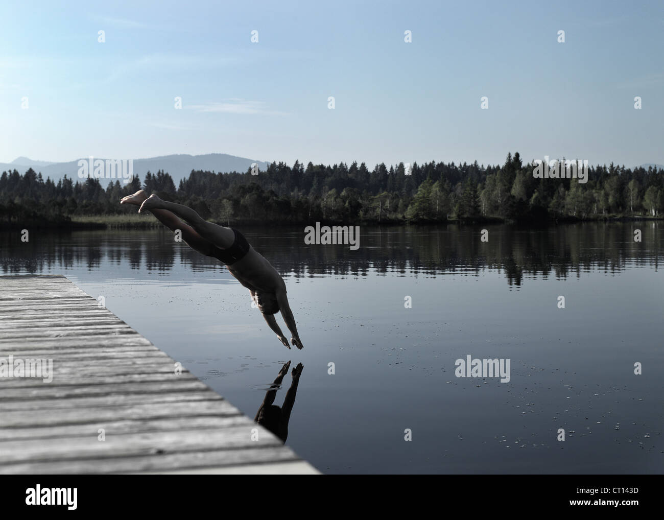 Man diving into still lake Stock Photo Alamy