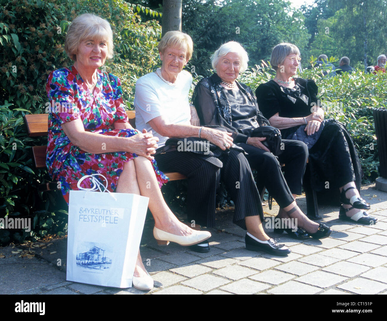 Visitors to the Richard Wagner Festival on a bench Stock Photo