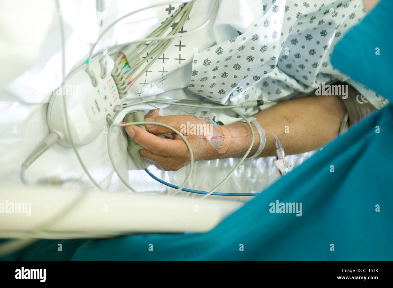 A patient has an intravenous drip inserted into the arm and an oximeter ...