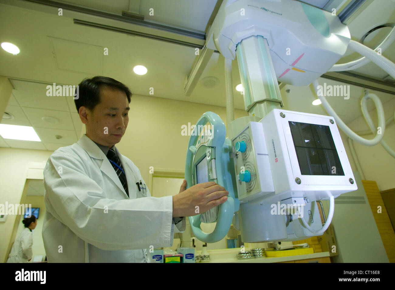 A radiologist adjusts an x-ray machine prior to use. Stock Photo