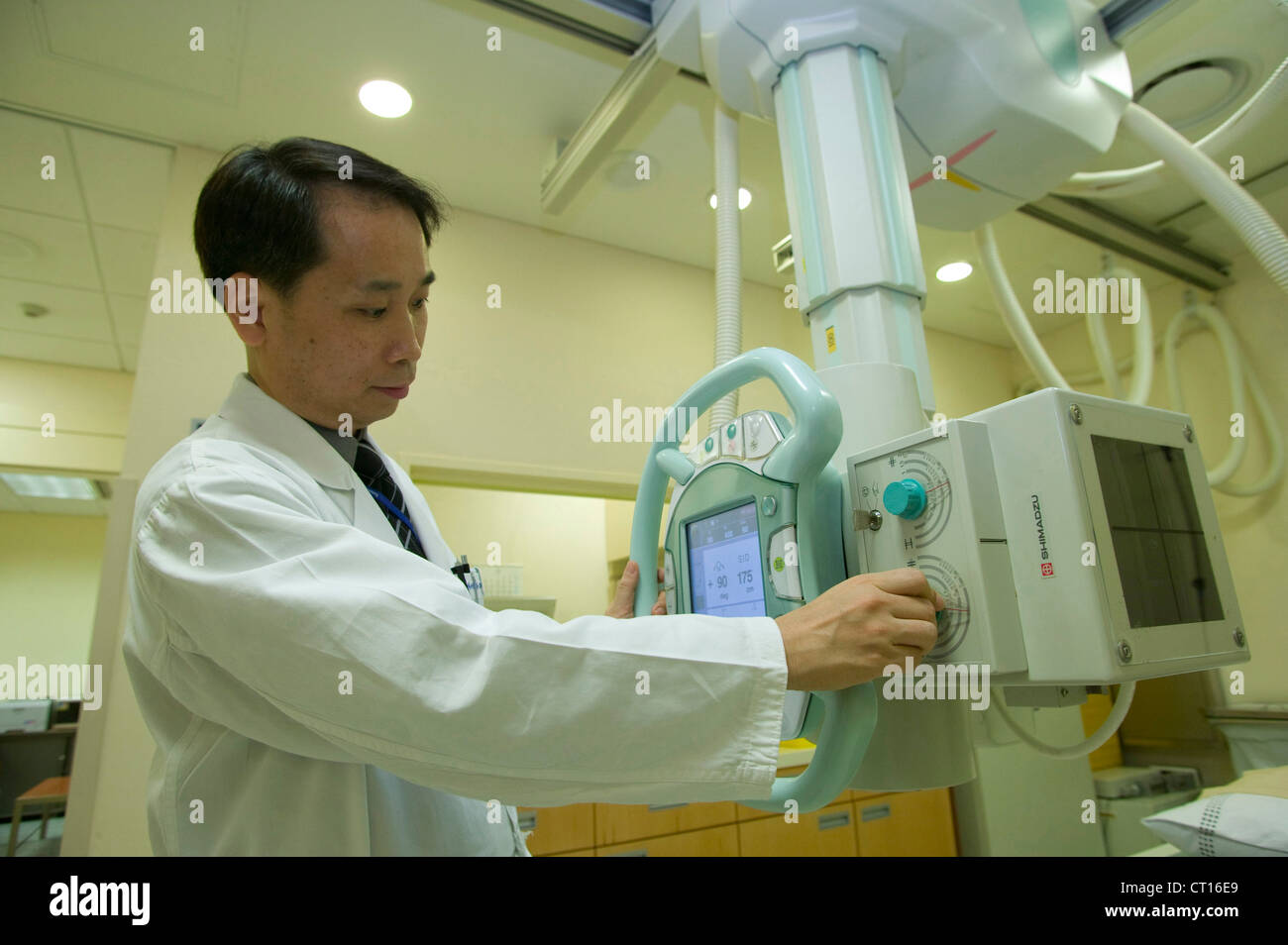 A radiologist adjusts an x-ray machine prior to use. Stock Photo