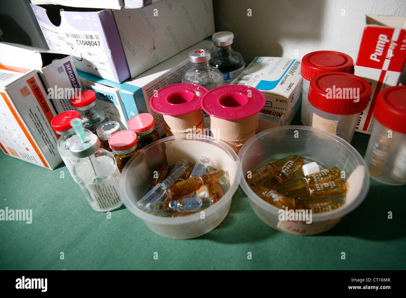 Various medical equipment on a tray in a theatre including drug ampoules, bandage tape and sutures. Stock Photo