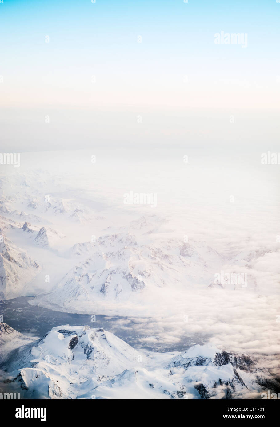 Fog rolling over snowy mountains Stock Photo