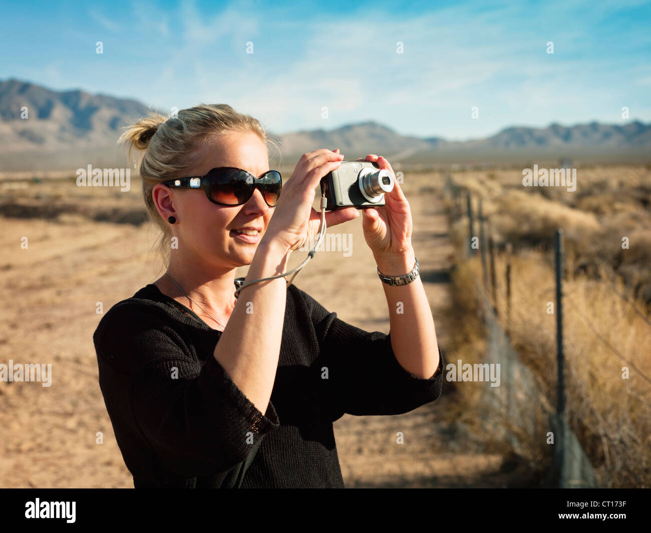 Woman taking pictures in rural field Stock Photo