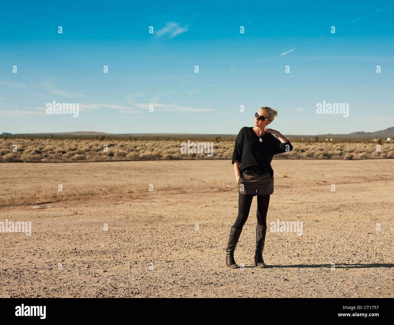 Woman walking in dry field Stock Photo