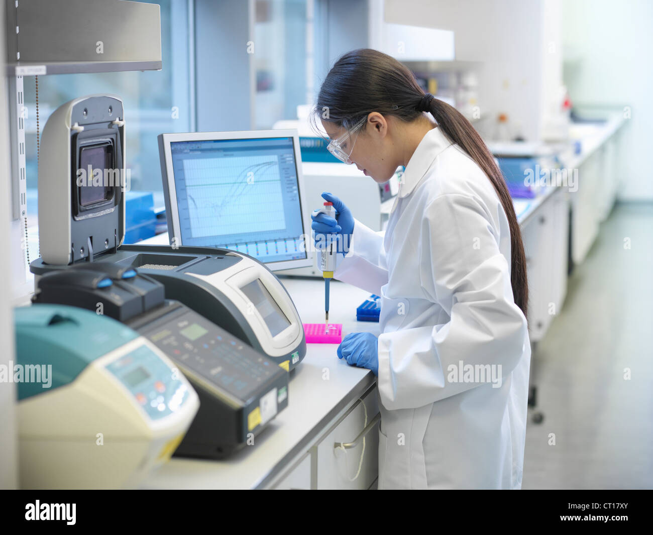 Scientists piping liquid into tubes Stock Photo