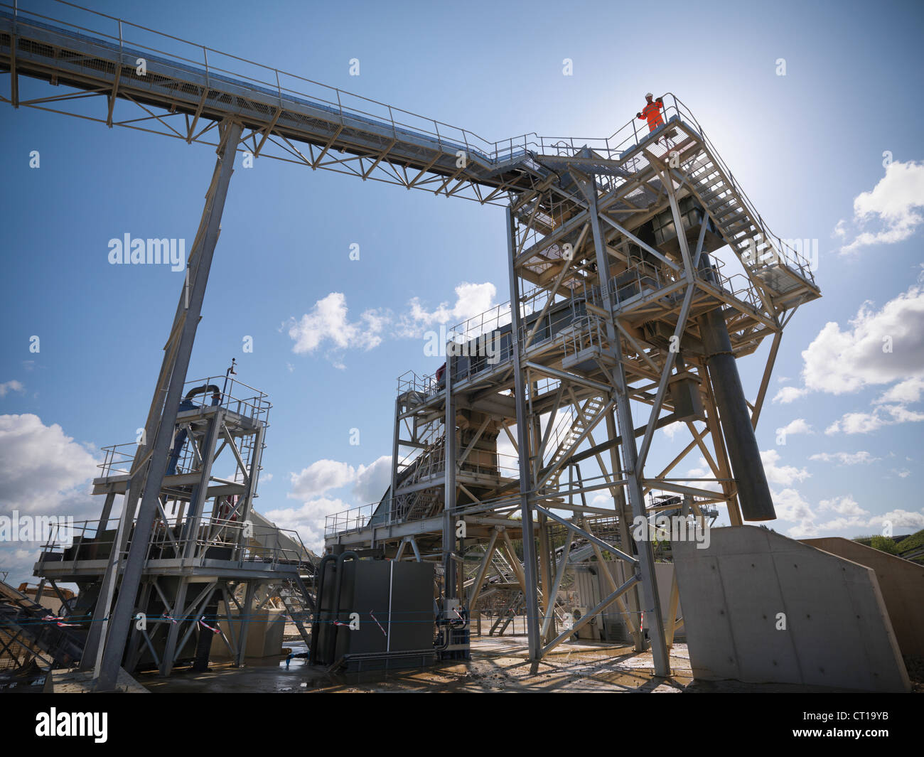 Worker standing on conveyor in quarry Stock Photo