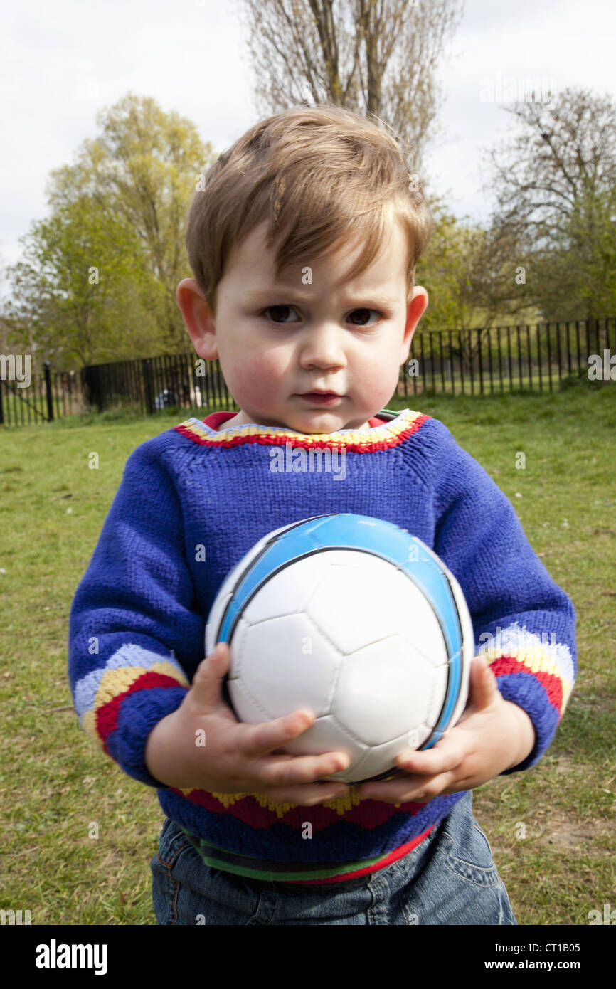 Boy holding soccer ball in backyard Stock Photo Alamy