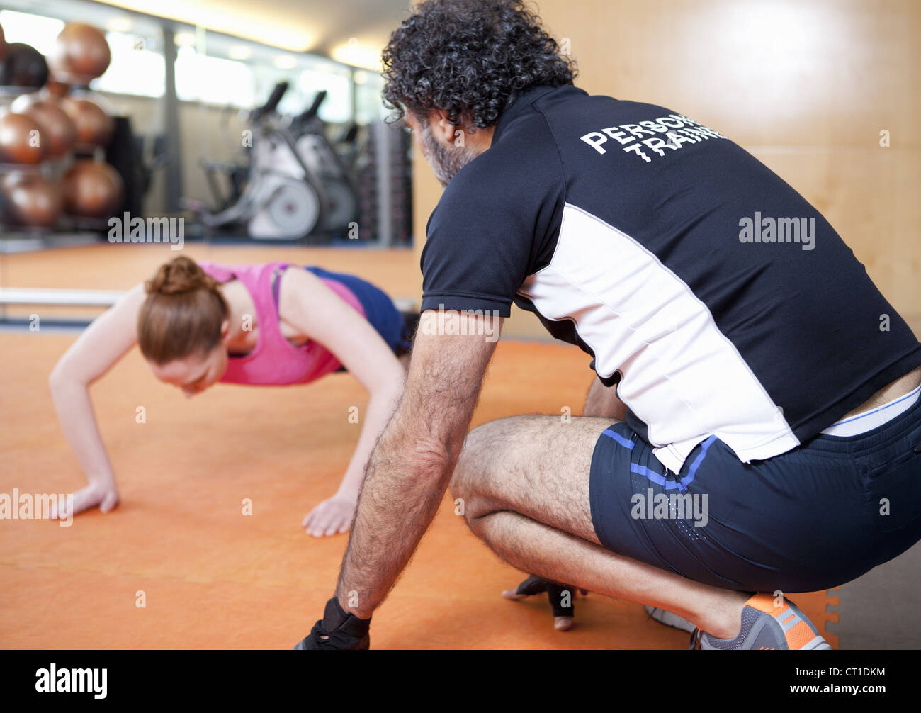 Woman working with trainer in gym Stock Photo