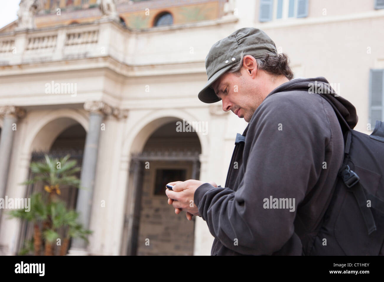 Man using cell phone on city street Stock Photo