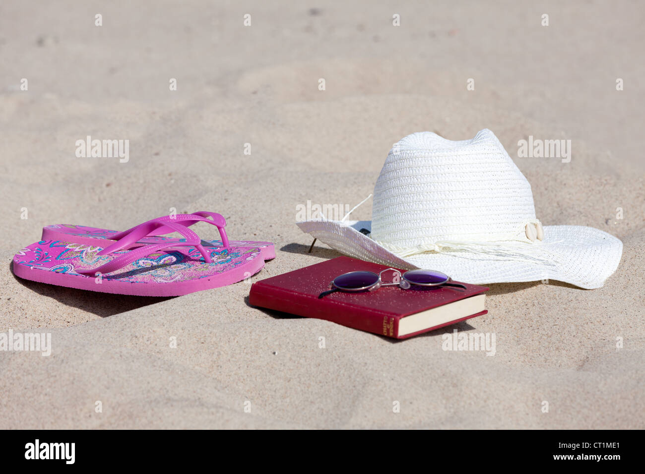 With a book and a straw hat on the beach and relax Stock Photo - Alamy