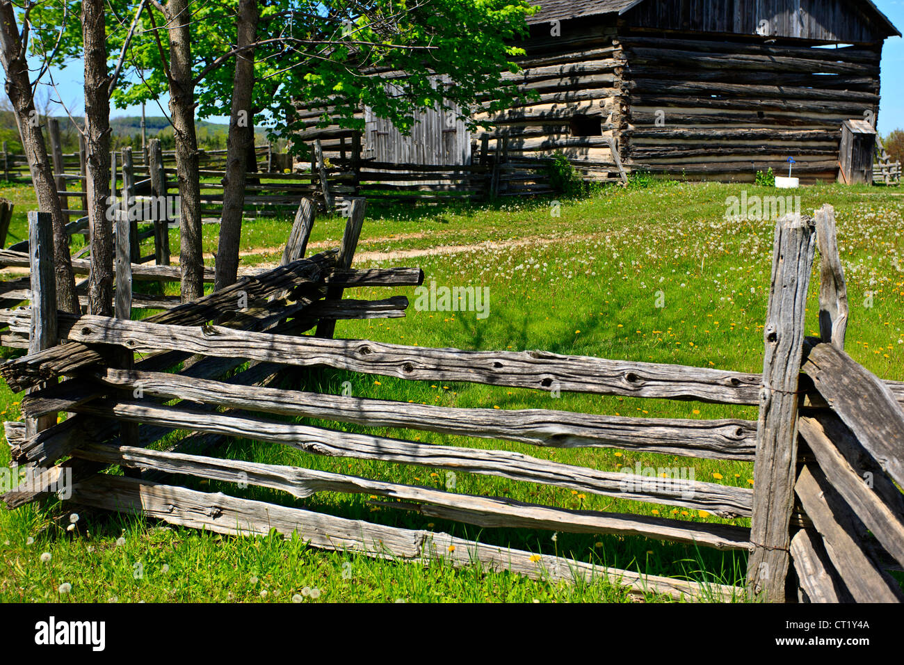 Split cedar rail farm fence with barns Stock Photo