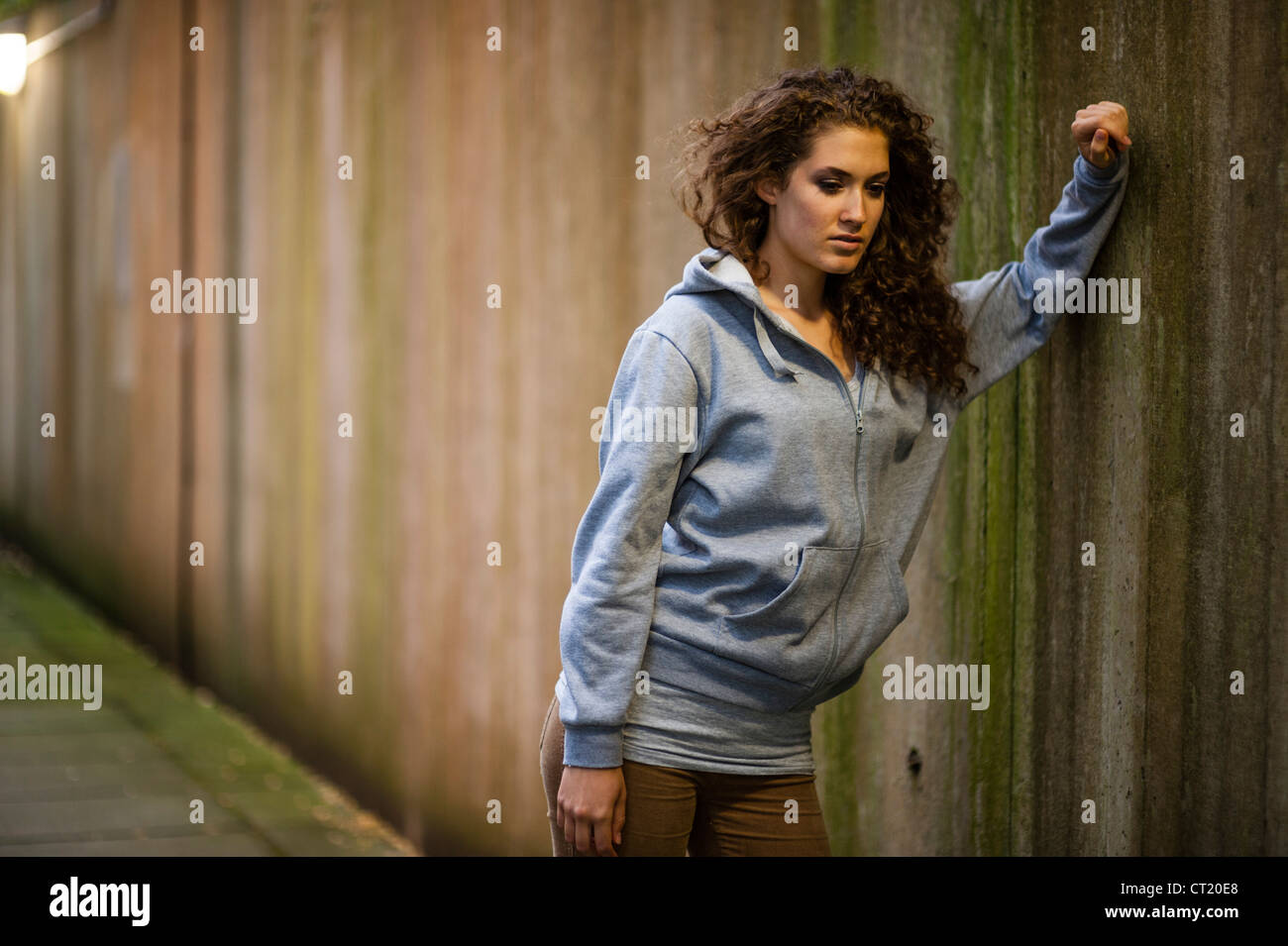 A young 20 year old slim attractive woman girl alone urban city UK Stock Photo
