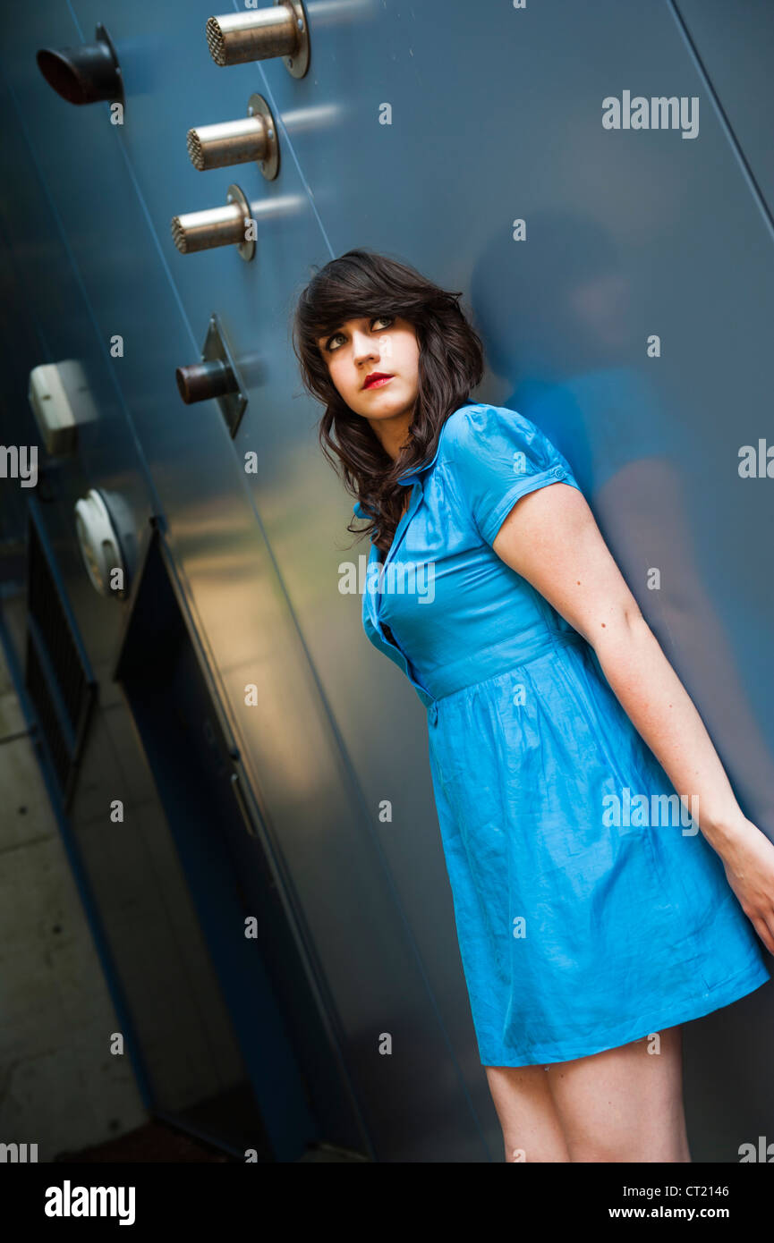 A young woman girl alone wearing a short blue dress, looking vulnerable, outdoors, UK Stock Photo