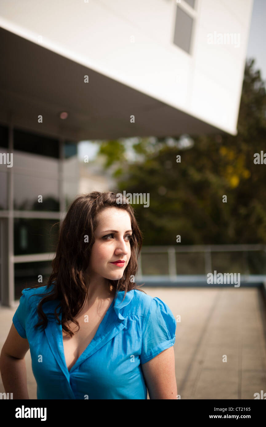 A young woman girl alone standing outdoors blue dress Stock Photo