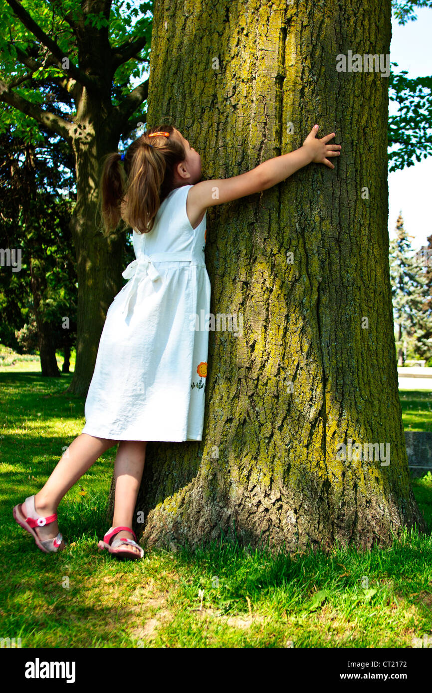 Four year old little girl hugging tree Stock Photo Alamy