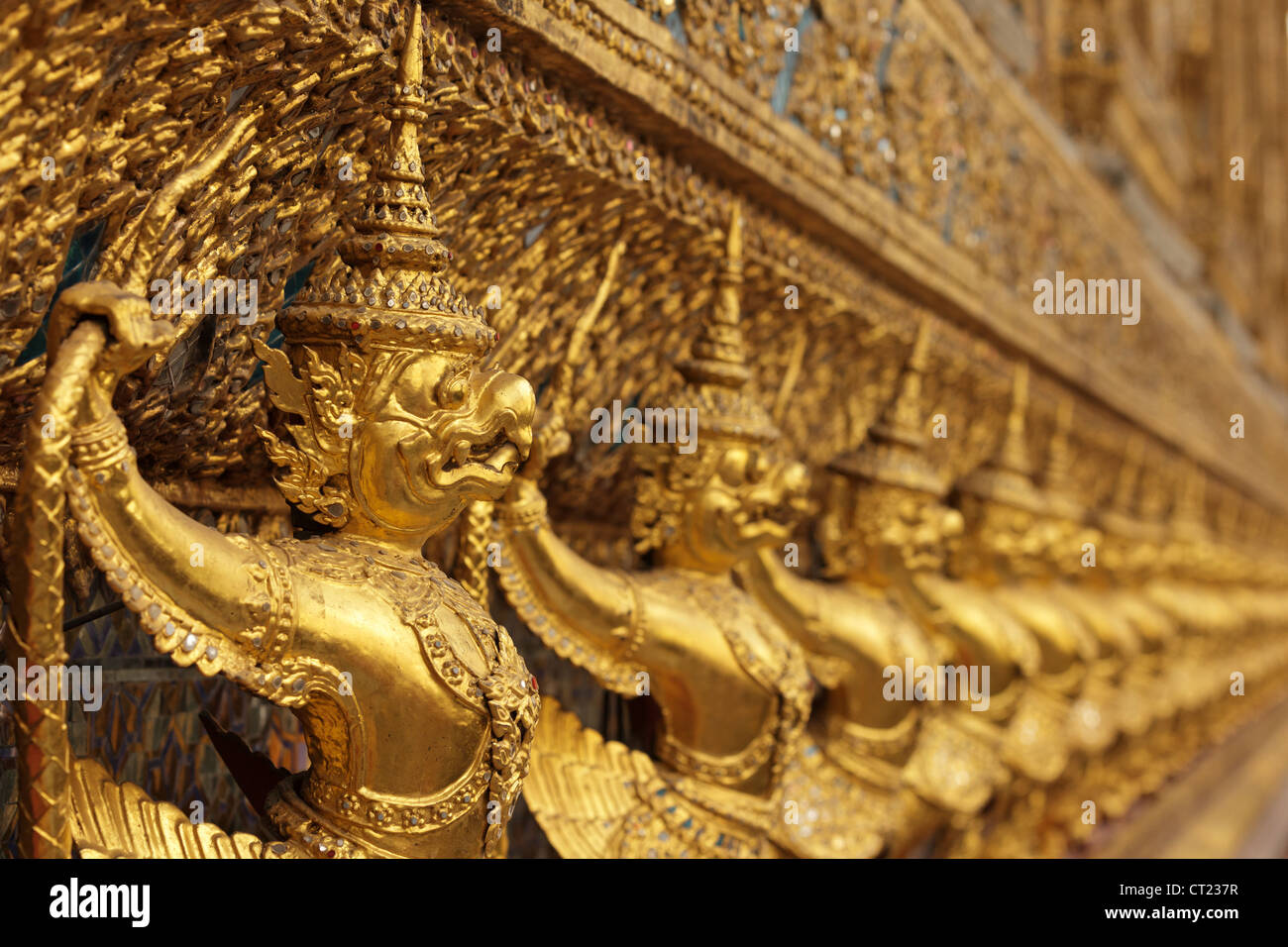 perspective view of golden religious statue in wat phra kaeo temple, Bangkok, Thailand, shallow depth of field Stock Photo