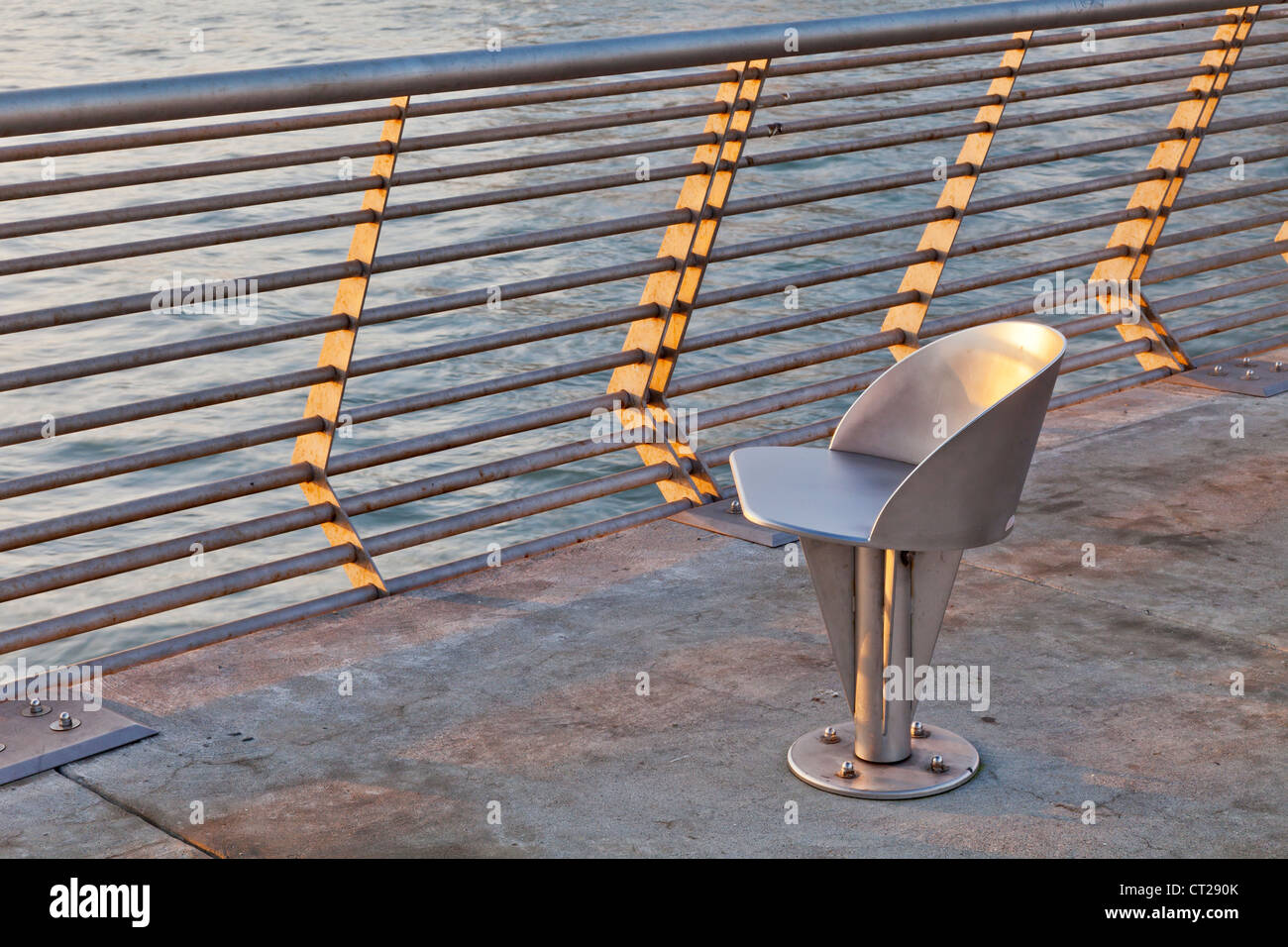 modern outdoor metal swivel chair at sunrise - San Francisco waterfront Pier 14 Stock Photo