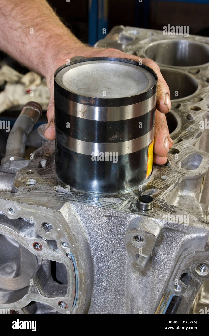 Piston being inserted into the bore of an engine block using a piston