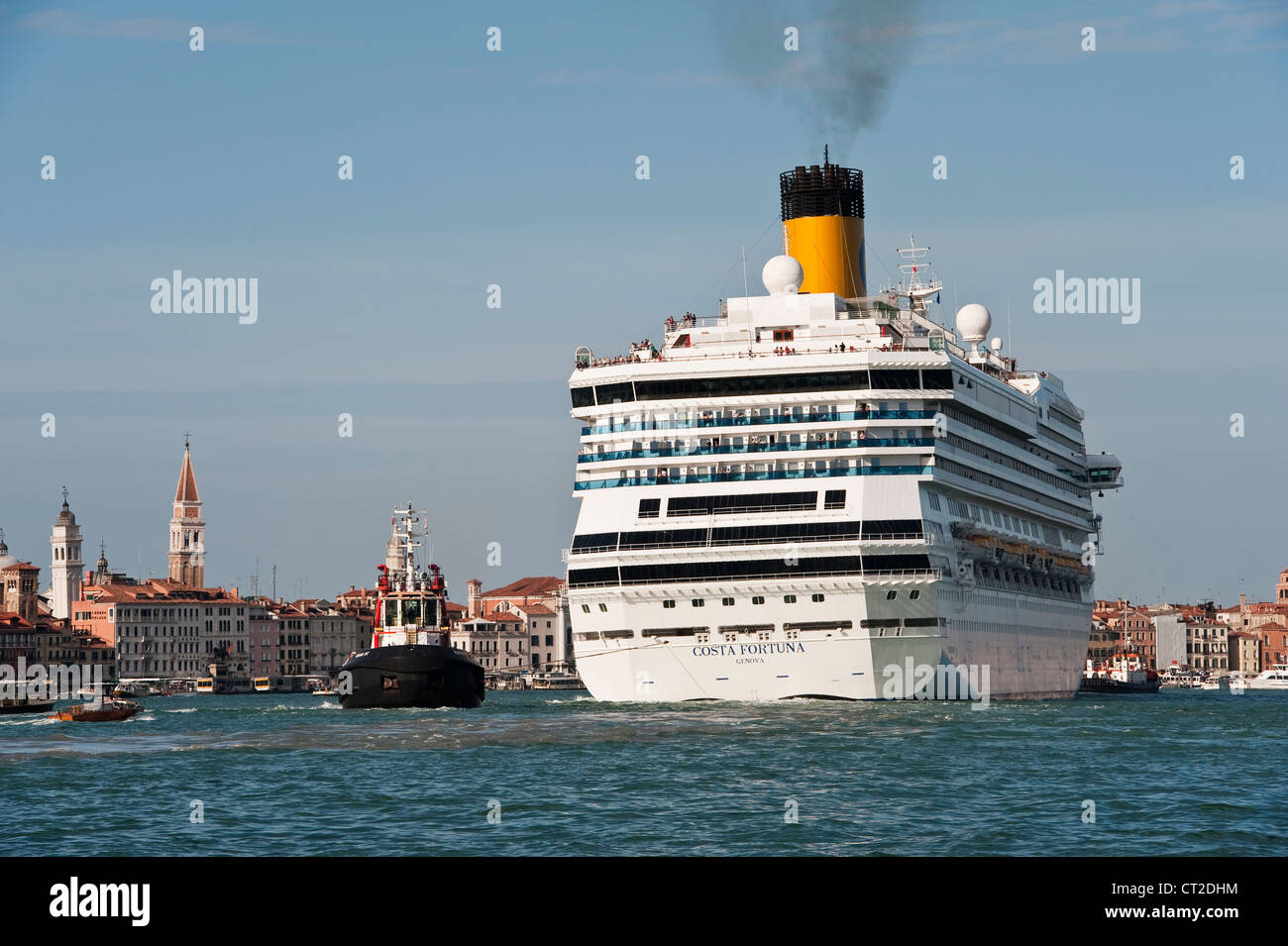 The huge cruise ship Costa Fortuna (owned by the cruise company Carnival Corporation) being towed past the Giudecca in Venice, Italy Stock Photo