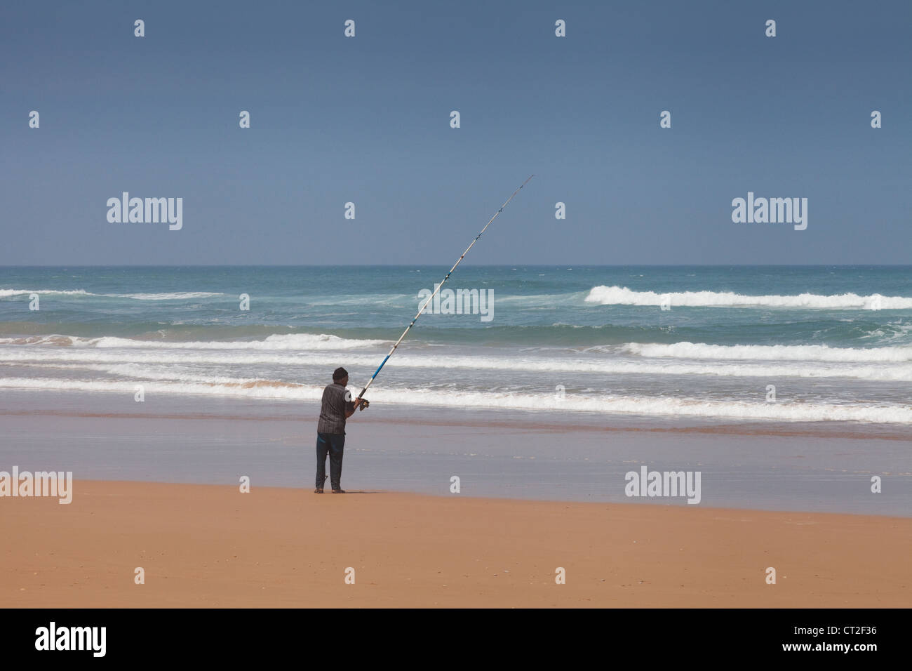 An arab berber man fishing in the Atlantic ocean from the beach near ...