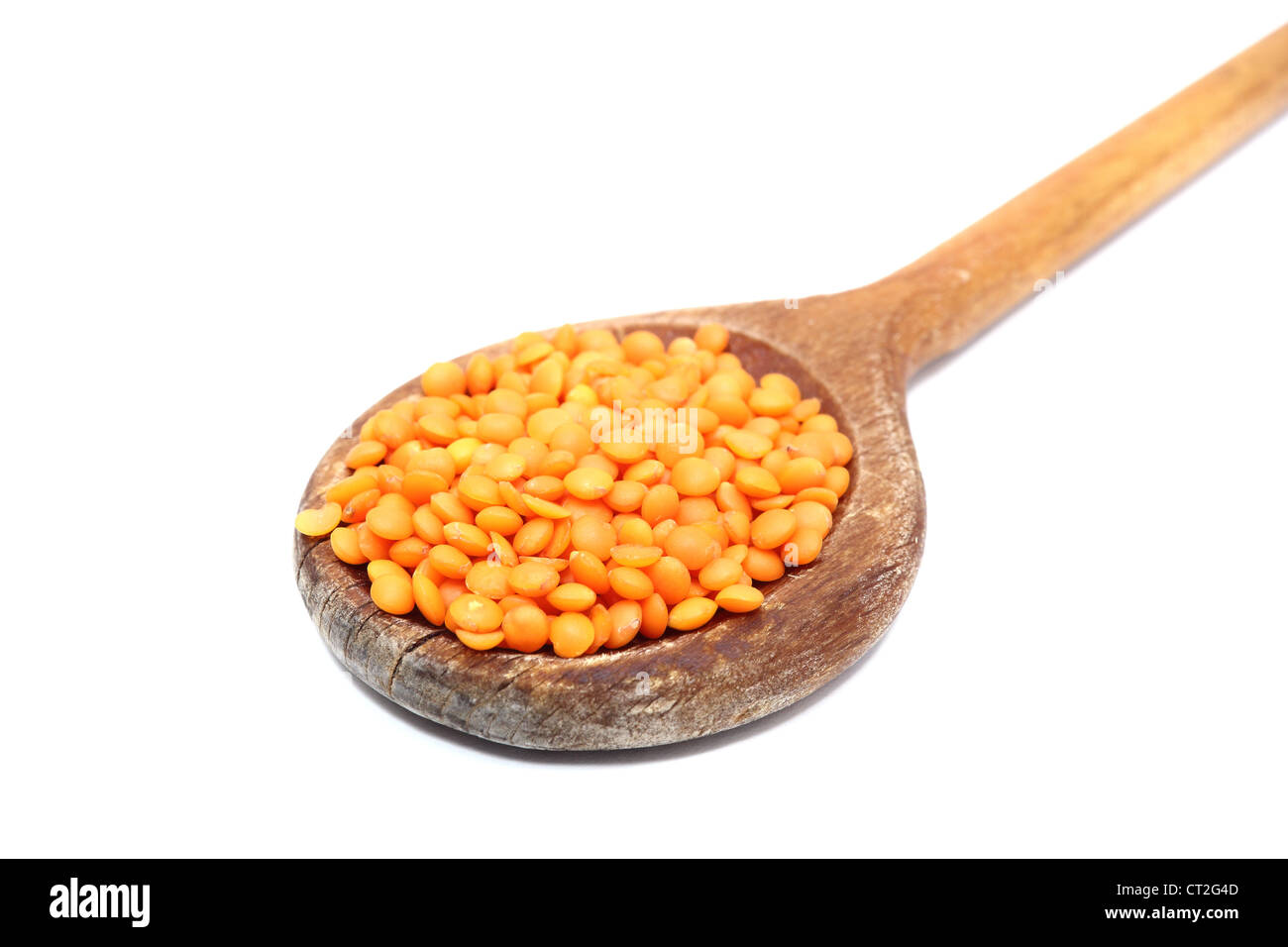 bunch of red lentil in old spoon over white Stock Photo