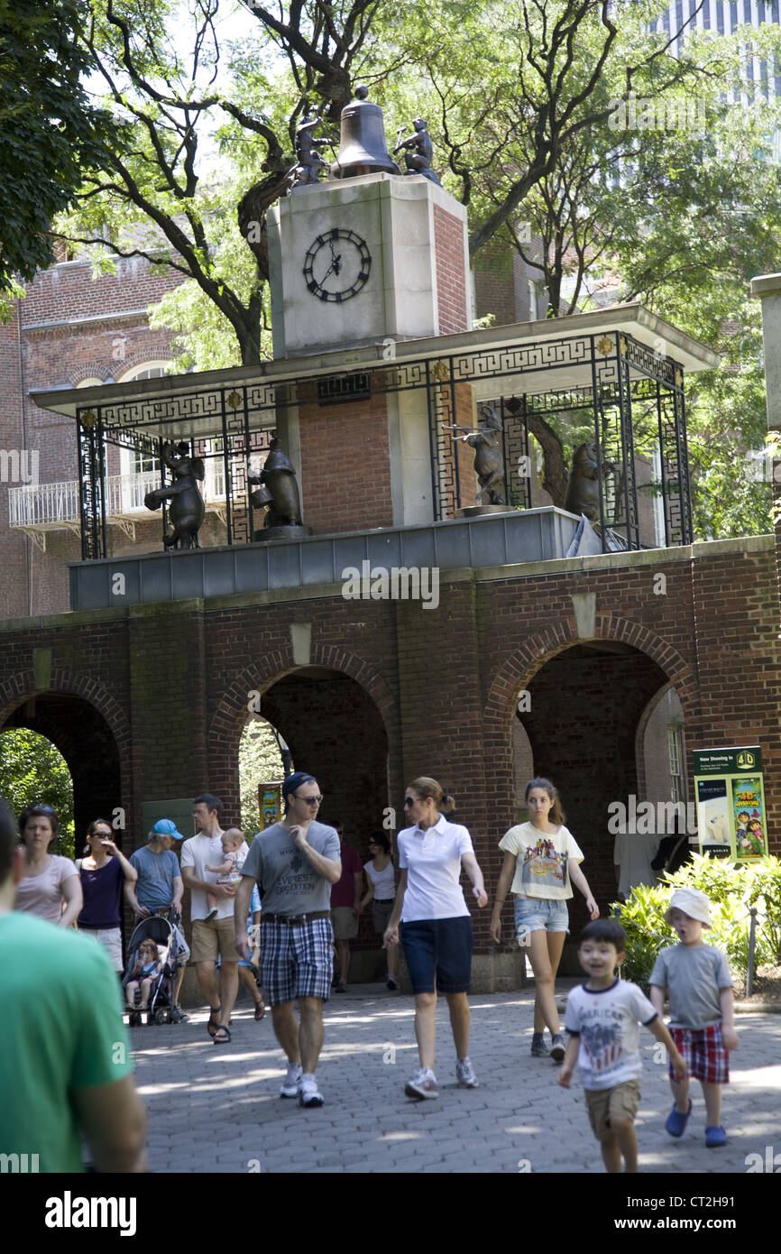 People walk by the famous Delacorte Musical Animal Clock near the zoo in Central Park, NYC. Stock Photo