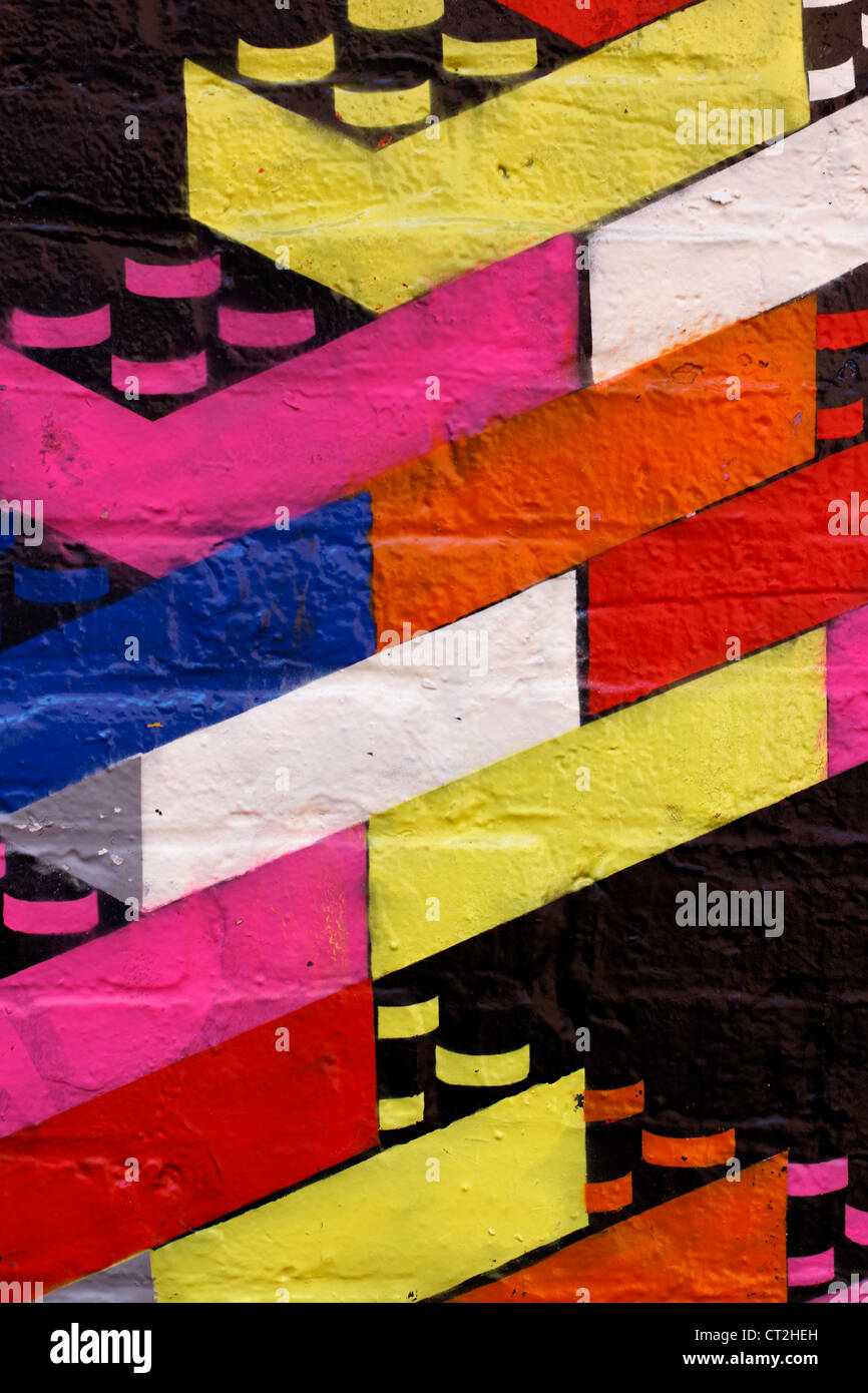Colorful graffiti of toy building bricks on a dark wall. Stock Photo