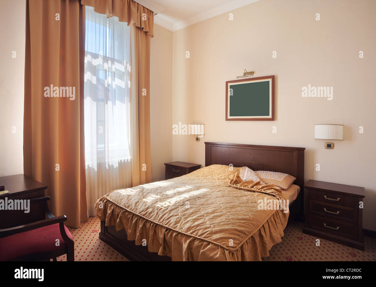 Interior of a hotel room for two, just a bed near window. Stock Photo