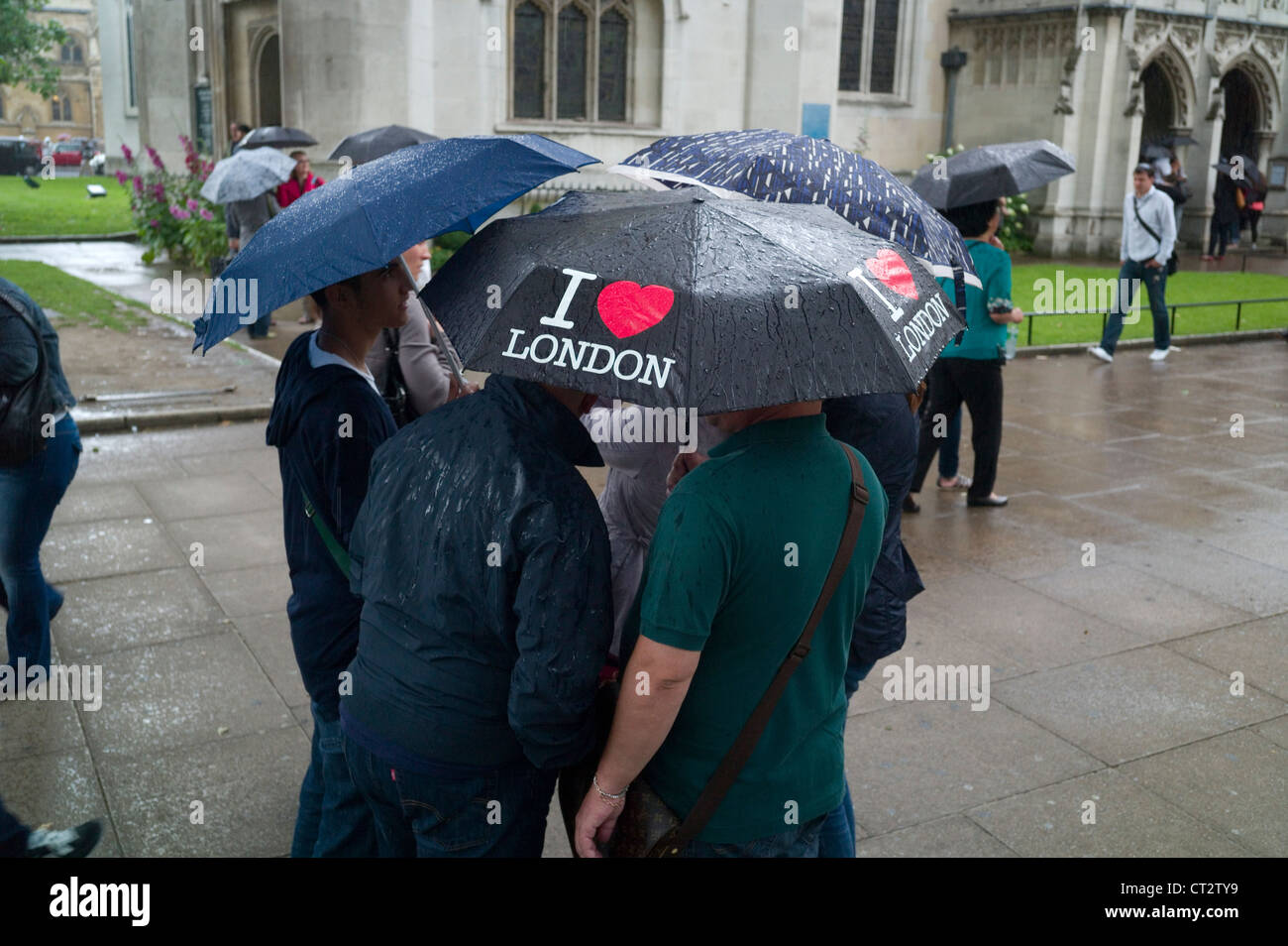 A group of tourists during a heavy shower under their umbrellas outside
