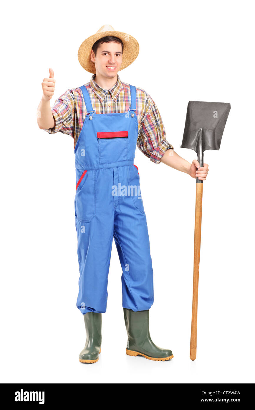 Full length portrait of a male agricultural worker holding a shovel and ...