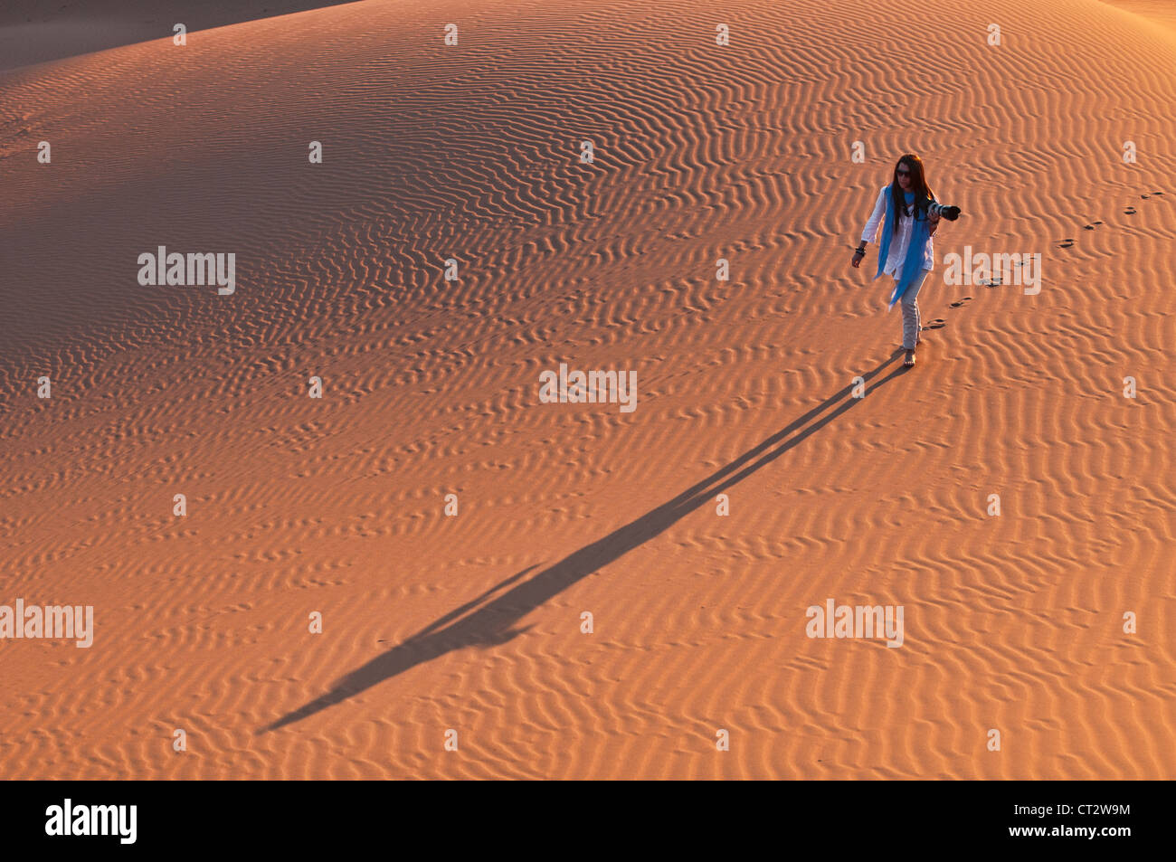photographer at sunset in the Sahara Desert at Erg Chigaga, Morocco Stock Photo