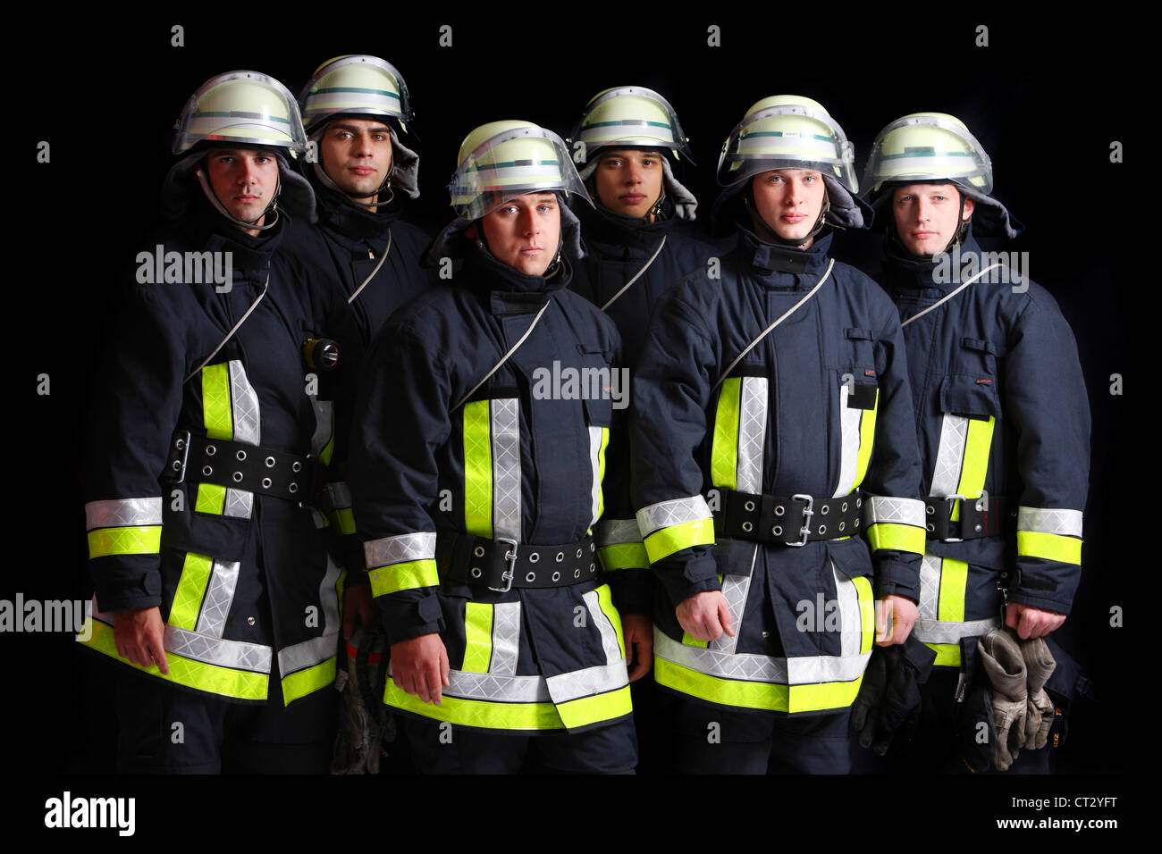 Firefighters in special fireproof suits, Nomex suit, helmet with visor, safety line. Professional fire eating. Stock Photo