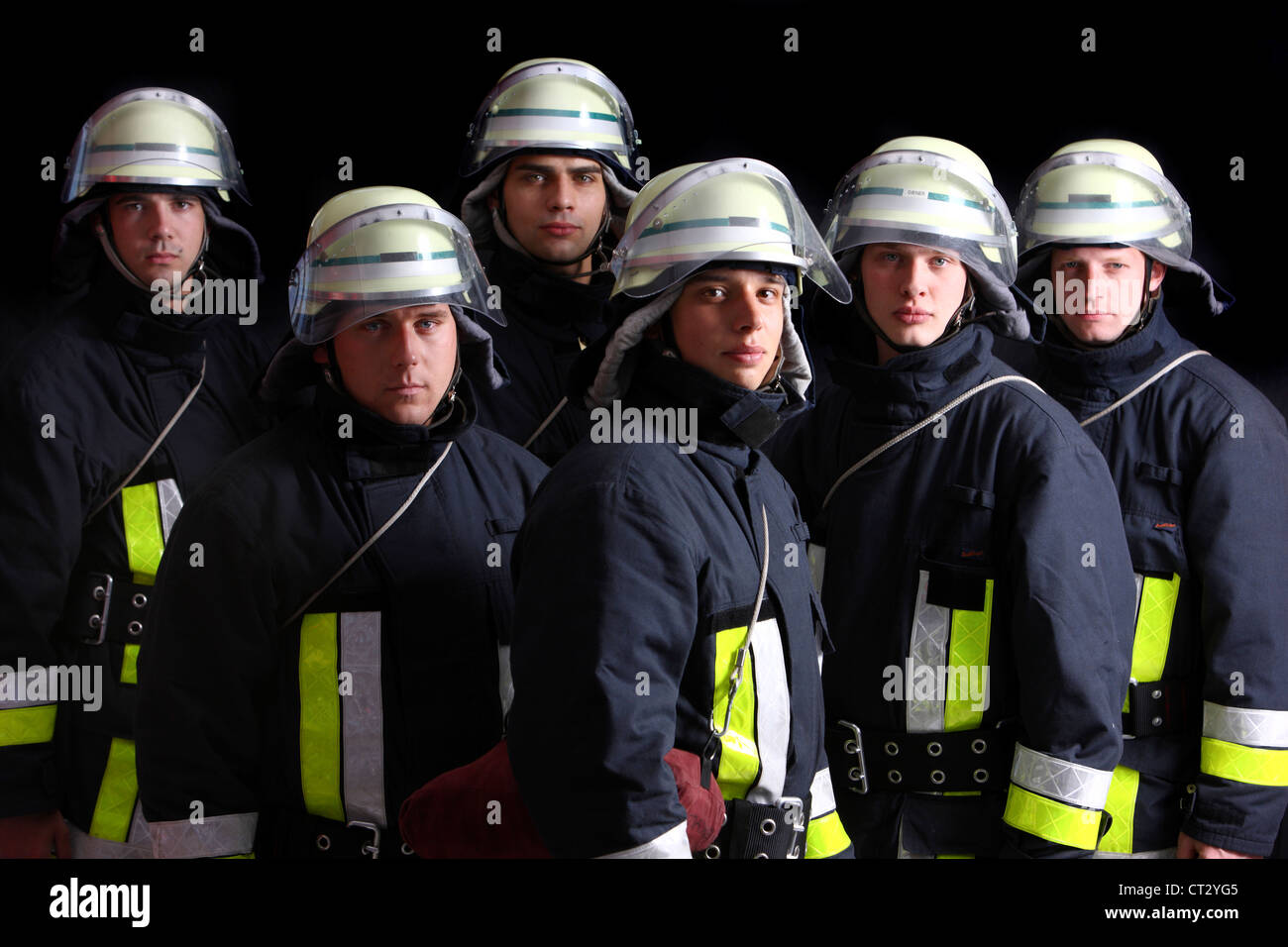 Firefighters in special fireproof suits, Nomex suit, helmet with visor, safety line. Professional fire eating. Stock Photo