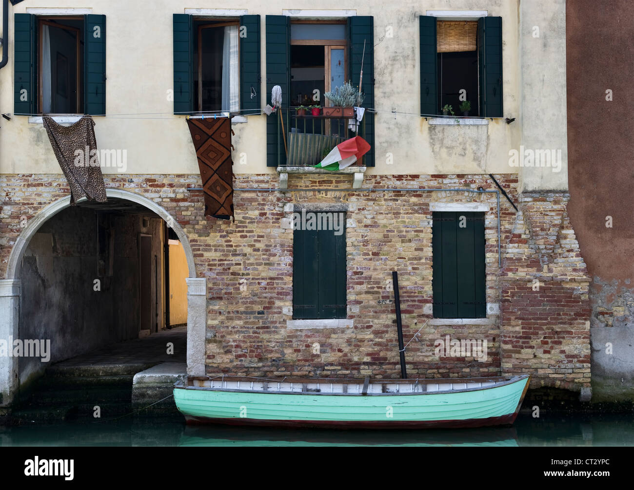 A rowing boat moored on a canal outside a house - a peaceful scene in the district (sestiere) of Cannaregio in Venice, Italy Stock Photo